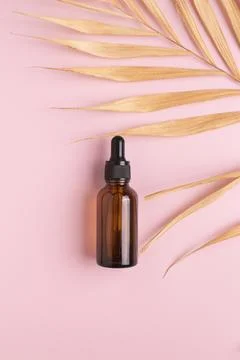 Cosmetic bottle with body and face oil and palm leaf, summer natural cosmetic Stock Photos