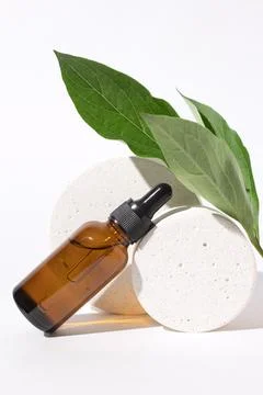 Cosmetic bottle with dropper on podium. Stock Photos