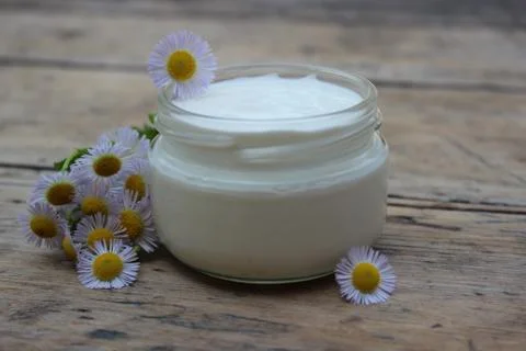 Cosmetic cream with chamomile flowers Stock Photos