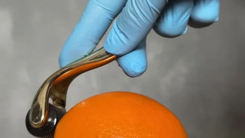Cosmetic Derma Roller rolling over an orange – Skincare Concept. Dermaroller Stock Footage 303021793