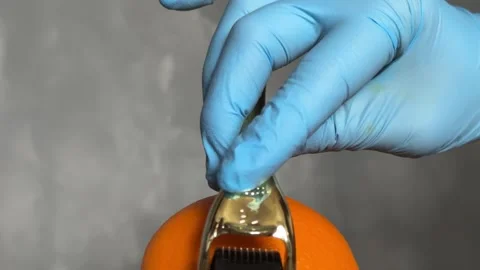 Cosmetic Derma Roller rolling over an orange – Skincare Concept. Dermaroller Stock Footage 303022004