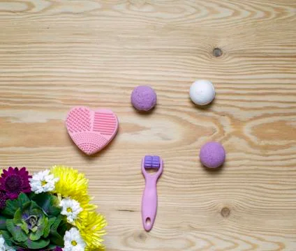 Cosmetic flat lay with roller for face, handmade bombs, massager heart, flowers 스톡 사진