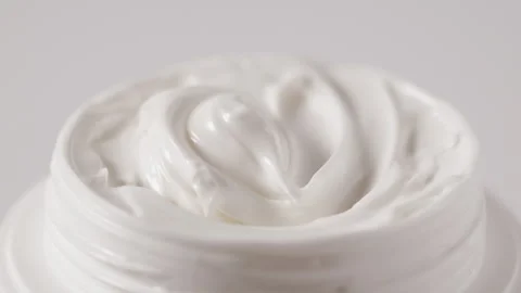 Cosmetic jar with smooth cream texture rotating on white background Stockbeeldmateriaal 334677527