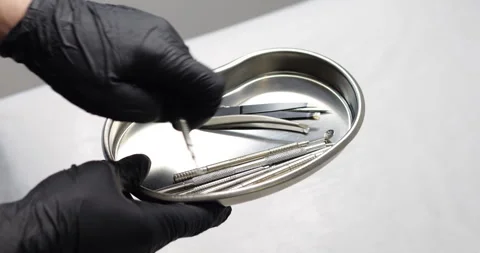 A cosmetic metal tool is being moved in a metal tray by hand. Video with soun Stock Footage 328609563