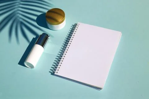 Cosmetic natural products on pastel blue background. Notebook for inscription Stock Photos