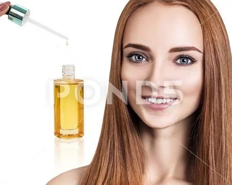 Cosmetic oil applying on face of young woman. Stock-Fotos