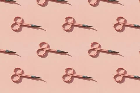 Cosmetic scissors on pink background. Stock Photos