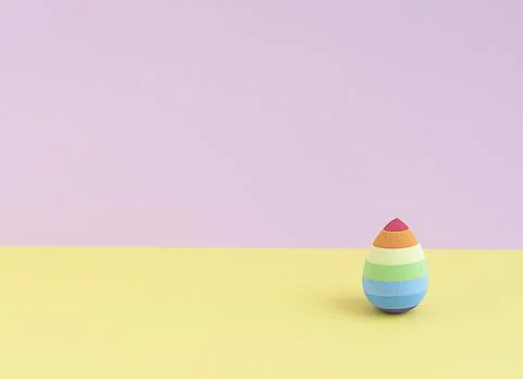 Cosmetic sponge in the form of an easter egg on a yellow-pink background. cop Stock Photos