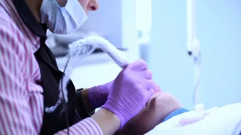 Cosmetician looks absorbed while doing permanent make-up to a client  Stock Footage 76030139