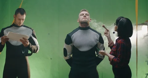 Cosmetician preparing an actor while others discussing Stock Footage 124884881