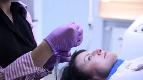 Cosmetician preparing a tool for permanent make-up and talking with a client Stock Footage 76030424