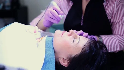 Cosmetician working with client while doing her permanent make-up  Stock Footage 76030013