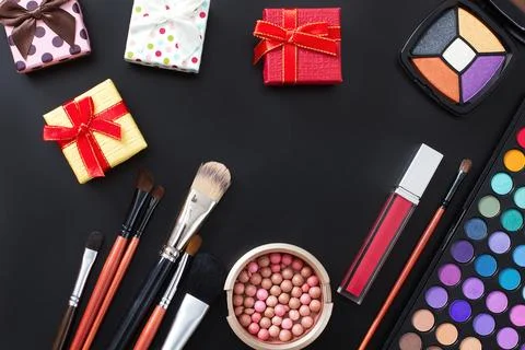 Cosmetics on black background and gift boxes. Top view and mock up. Copy sp.. Stock Photos