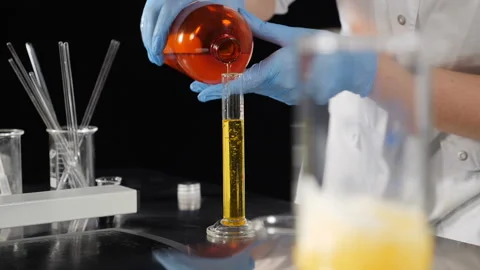 Cosmetics manufacture industry. Laboratory assistants mixing ingredients in Stock Footage