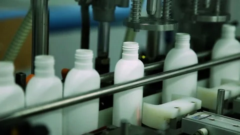 Cosmetics manufacturing plant. White bottles on the belt conveyor. Shampoo Stock Footage