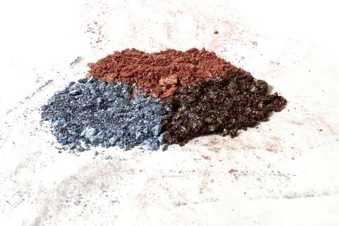 Cosmetics. Scattered multicolored eye shadow isolated on a white background Stock Photos