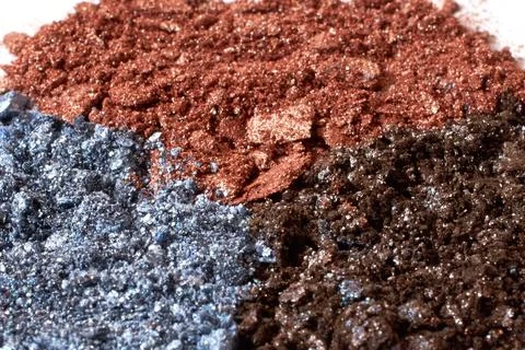 Cosmetics. Scattered multicolored eye shadow isolated on a white background Stock Photos