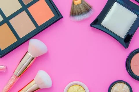 Cosmetics set on pink background. Makeup frame made from brushes for make-up Stock Photos