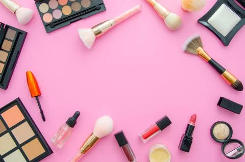 Cosmetics top view on a pink table. Workplace flat lay with cosmetics, lipstick Stock Photos