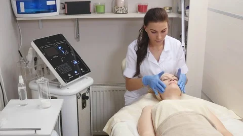 Cosmetologist applies cream on the skin of the client Stock Footage