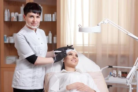 Cosmetologist applying permanent make up on eyebrows- eyebrow tattoo Stock Photos