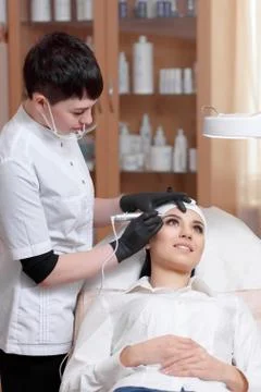 Cosmetologist applying permanent make up on eyebrows- eyebrow tattoo Stock Photos