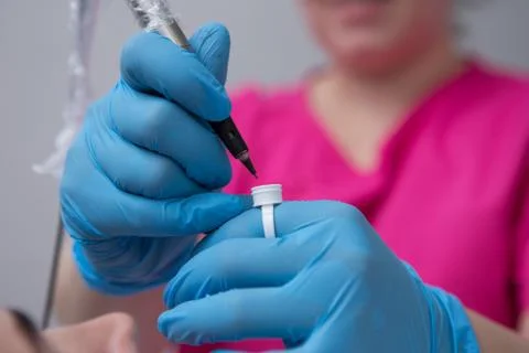 Cosmetologist applying permanent make up on eyebrows- eyebrow tattoo Stock Photos