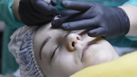 Cosmetologist applying permanent makeup on eyebrow-eyebrow tattoo. Stock Footage 88213813