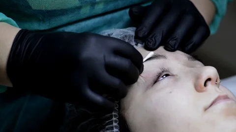 Cosmetologist applying permanent makeup on eyebrow-eyebrow tattoo. Stock Footage 88257542