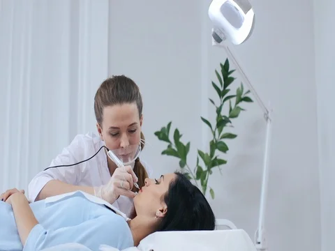 Cosmetologist applying permanent makeup on lips Stock Footage 75602336