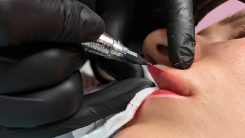 Cosmetologist applying permanent makeup on lips. Cosmetology procedure. Applying Video stock 119892209