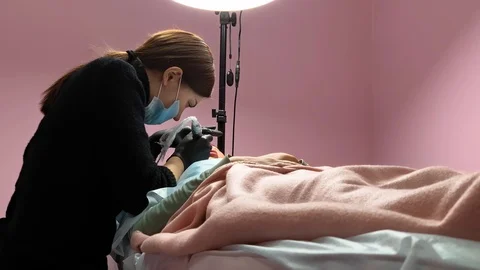Cosmetologist applying permanent makeup on lips. Cosmetology procedure. Applying Video stock 119892257