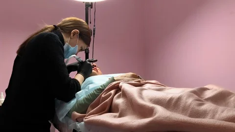 Cosmetologist applying permanent makeup on lips. Cosmetology procedure. Applying Video stock 119892471