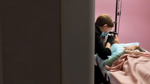 Cosmetologist applying permanent makeup on lips. Cosmetology procedure. Applying Video stock 119892486