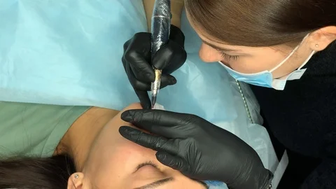 Cosmetologist applying permanent makeup on lips. Cosmetology procedure. Applying Video stock 119892591