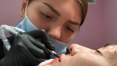 Cosmetologist applying permanent makeup on lips. Cosmetology procedure. Applying Video stock 119892604