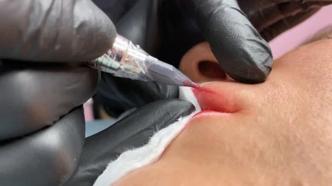 Cosmetologist applying permanent makeup on lips. Cosmetology procedure. Applying Video stock 119892648