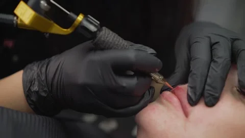 Cosmetologist applying permanent makeup tattoo on lips. Stock Footage 285506892