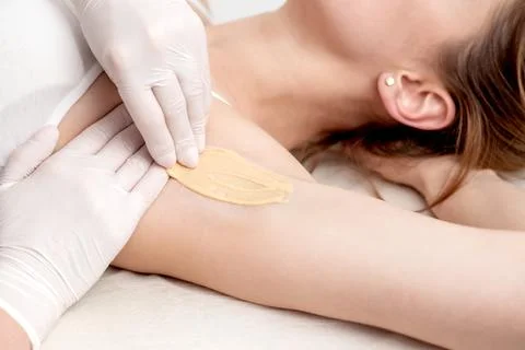 Cosmetologist applying wax paste on armpit Foto stock