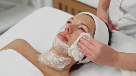 Cosmetologist cleaning a patient face to remove anesthesia Stock Footage 294707491