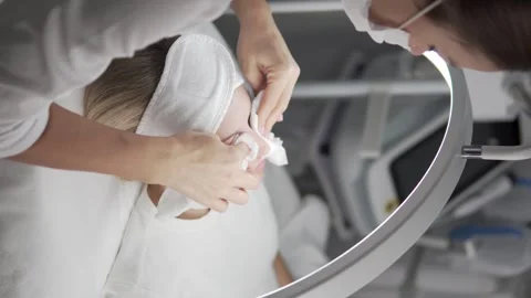 The cosmetologist cleans the client's face before the procedure Stock Footage 288447982