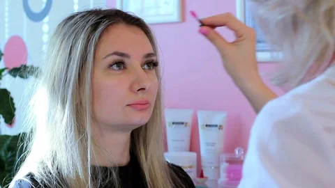 Cosmetologist combs eyebrows a brush to the beautiful woman Vídeos de archivo 73933600