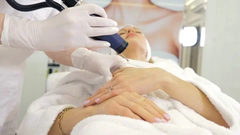 Cosmetologist dermatologist performs hardware laser hair removal to a patient in Stock Footage 169518199