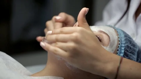 The cosmetologist does face massage to the client in excess of the mask Stock-Footage 81635056