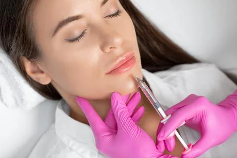 Cosmetologist does injections for lips augmentation and anti wrinkle in the n Stock Photos