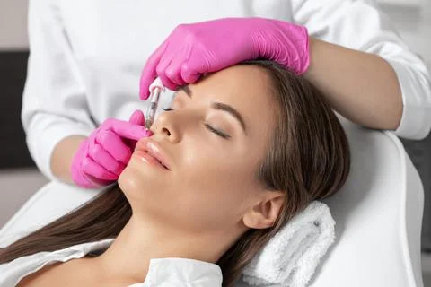 Cosmetologist does injections for lips augmentation and anti wrinkle in the n Stock Photos