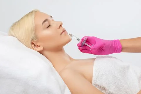 Cosmetologist does injections for lips augmentation and anti wrinkle in the n Stock Photos