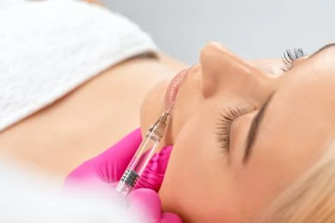 Cosmetologist does injections for lips augmentation and anti wrinkle in the n Stock Photos