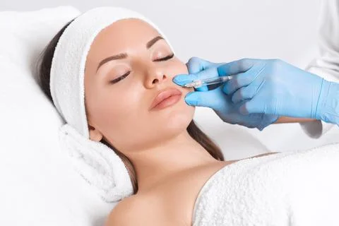 Cosmetologist does injections for lips augmentation and anti wrinkle in the n Stock Photos