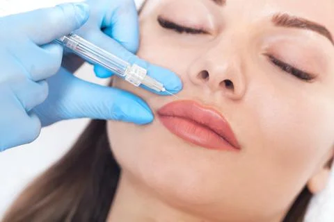 Cosmetologist does injections for lips augmentation and anti wrinkle in the n Stock Photos